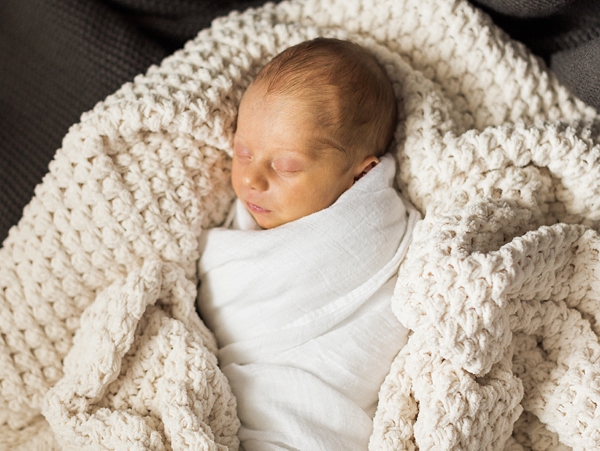 A cozy photo of a newborn baby boy taken by j. photography