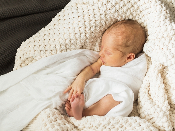 A cozy and natural photo of a newborn boy with neutral colors taken by j. photography